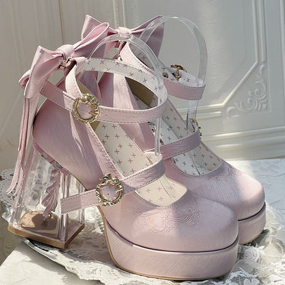 Pink high-heeled shoes with decorative bows and straps on a white lace surface.