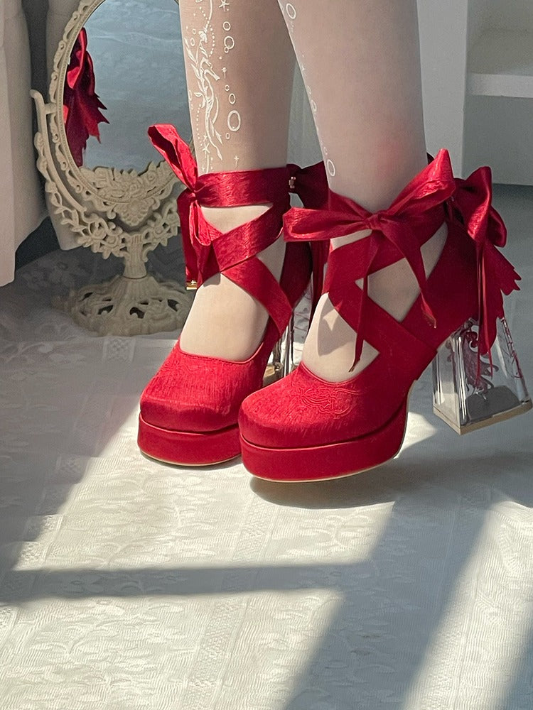 Red platform heels with bows worn by a person, standing on a light-colored floor.