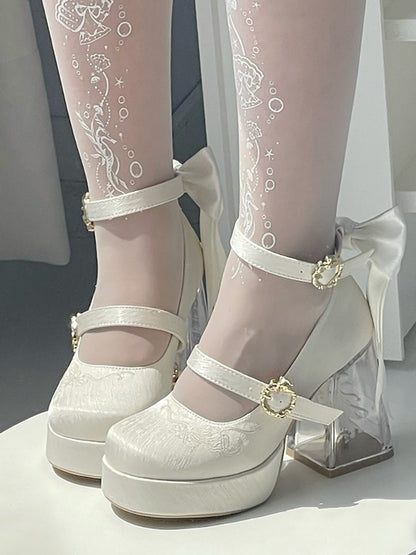 White lace platform shoes with clear heels on a neutral background