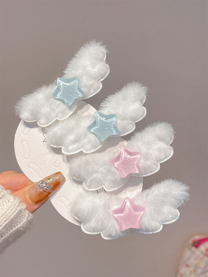 Four white fluffy cloud-shaped hair clips with star accents in light blue and pink, held on a white display card by a hand with glittery nail polish.