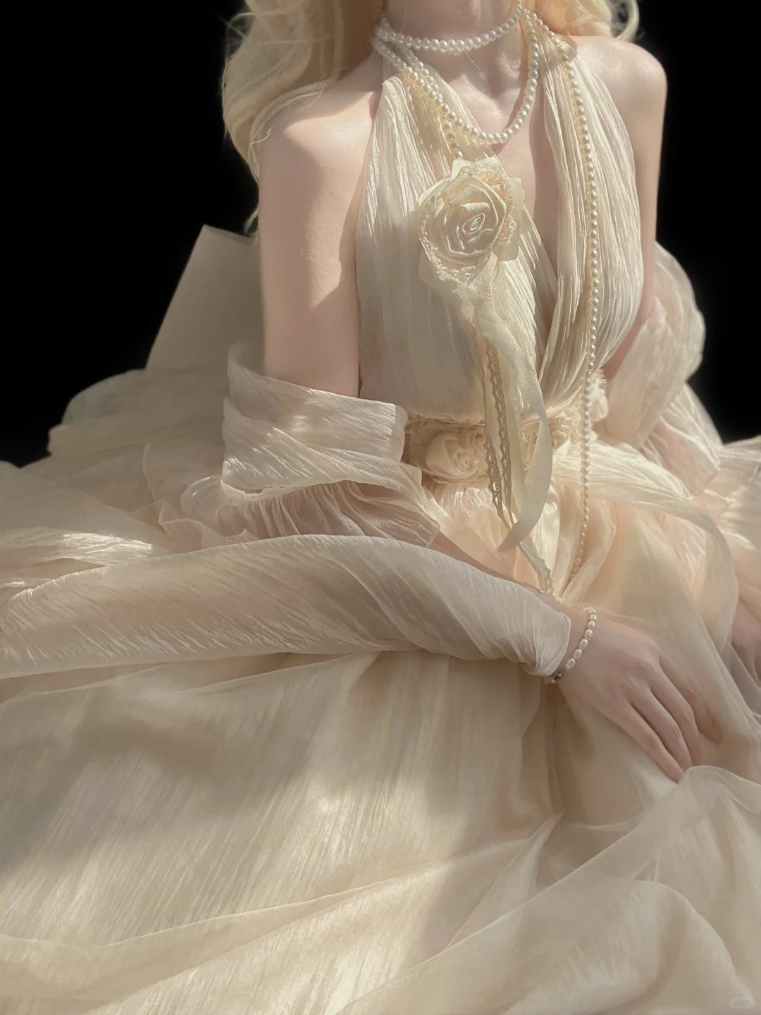 Beige evening gown with intricate details and a black background