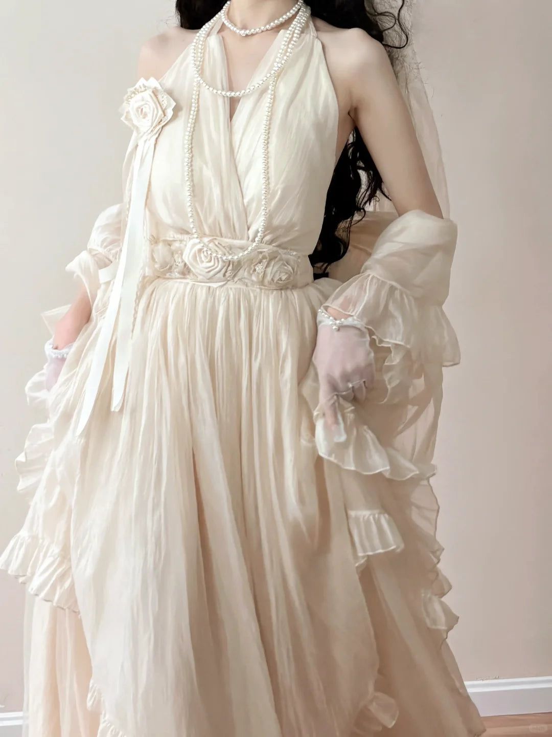 Woman wearing a vintage-style wedding dress with floral details and a veil.