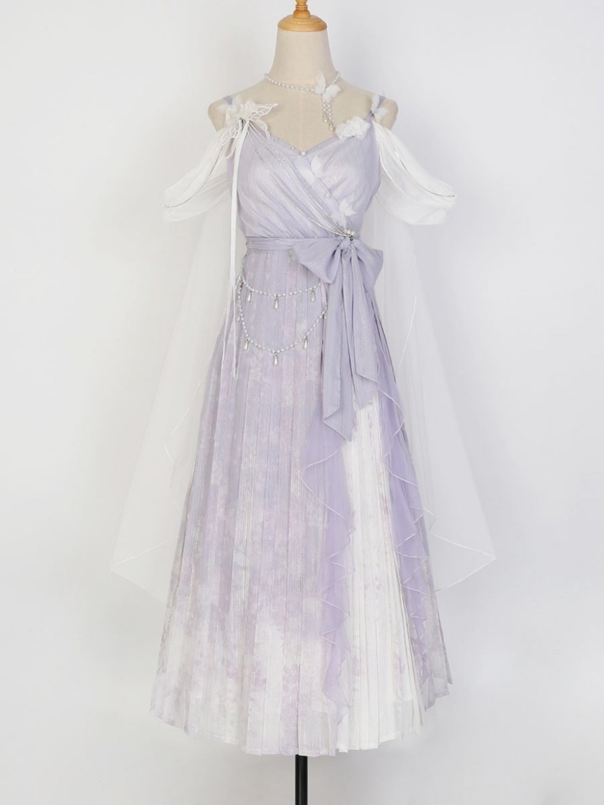A lavender and white tie-dye Lolita dress displayed on a mannequin with a matching sheer white tulle capelet and veil.