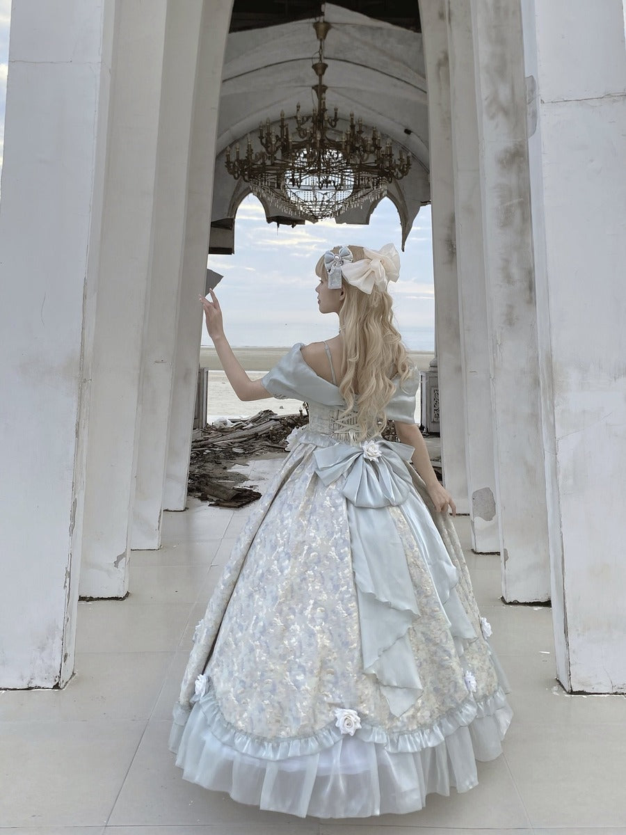 A woman wearing a voluminous pale blue and white ballgown with intricate lace and ruffle details, standing in a white arched corridor and taking a mirror selfie.