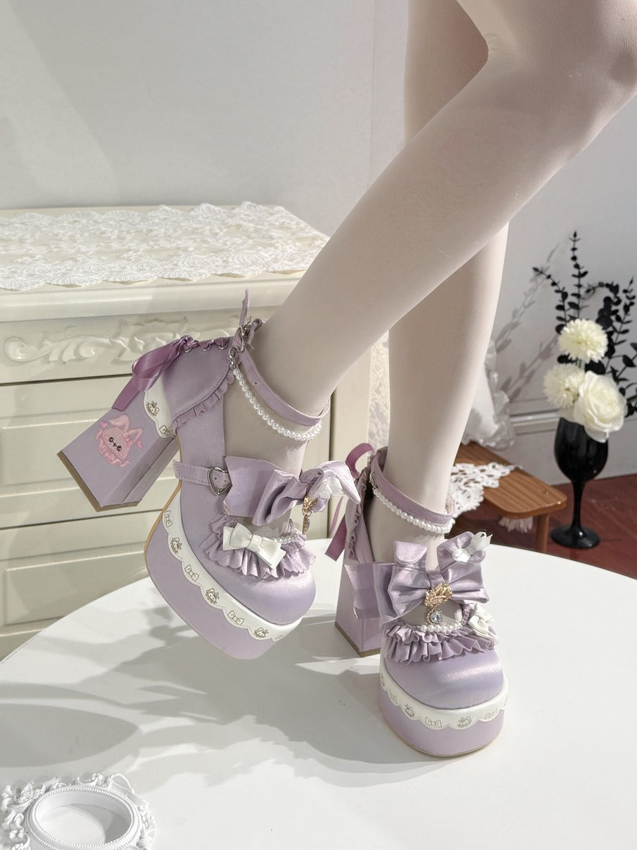 A pair of lavender platform Lolita-style shoes with white lace trim, bows, and pearl-like details, shown being worn with white tights in an indoor room setting.