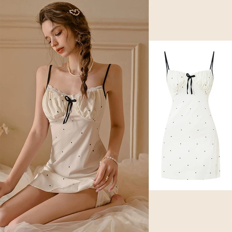 A woman wearing a cream satin slip dress with black polka dots and a black bow detail, shown in a bedroom setting alongside a clean product image on the right.