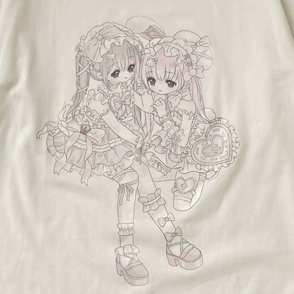 A close-up of a white T-shirt featuring a detailed line art graphic of two anime-style girls in elaborate lolita outfits, holding heart-shaped accessories.