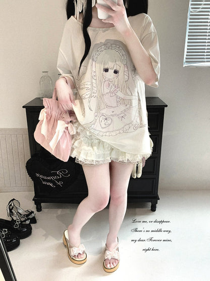 A person takes a mirror selfie showing a light cream-colored short-sleeve t-shirt with a large anime girl graphic, a matching ruffled mini skirt, and pink slip-on sandals. The setting is a bedroom with a black wooden cabinet in the background.