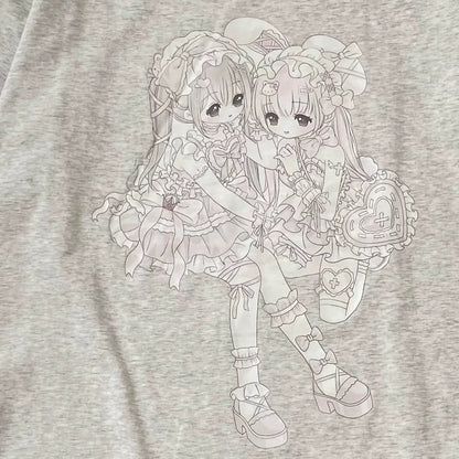 Close-up of a light heather gray t-shirt featuring a detailed line art graphic of two anime-style girls in elaborate school uniform outfits.
