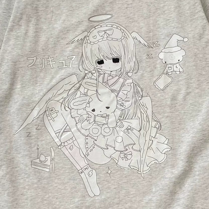 Close-up of a light heather gray t-shirt featuring a black line art graphic of a cute anime-style angel girl holding a bunny, with Japanese text and small sleeping character illustrations.