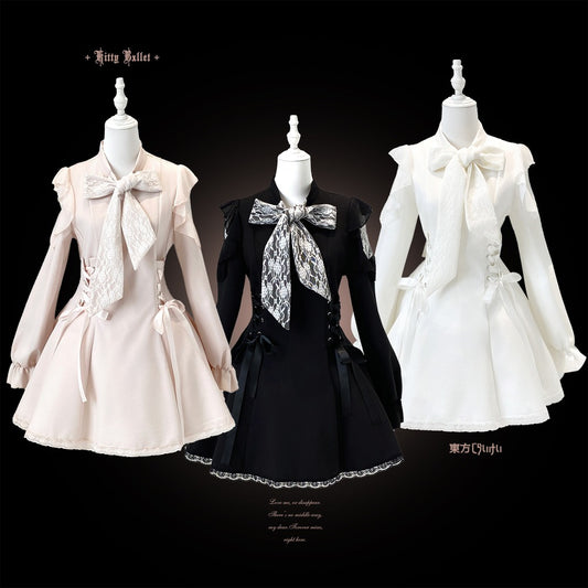 Three gothic-style dresses displayed on mannequins against a black background: a pale blush pink dress, a black dress with a silver patterned bow, and a white dress.