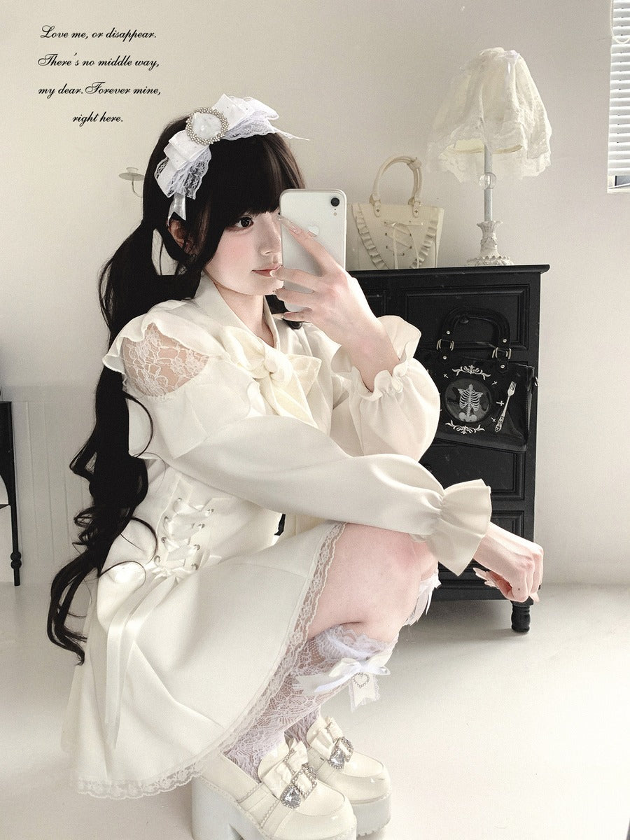 A person wearing a cream-colored Lolita-style dress with lace details, a matching headband, and white platform shoes, taking a mirror selfie in a room with a black cabinet and a vintage-style lamp.