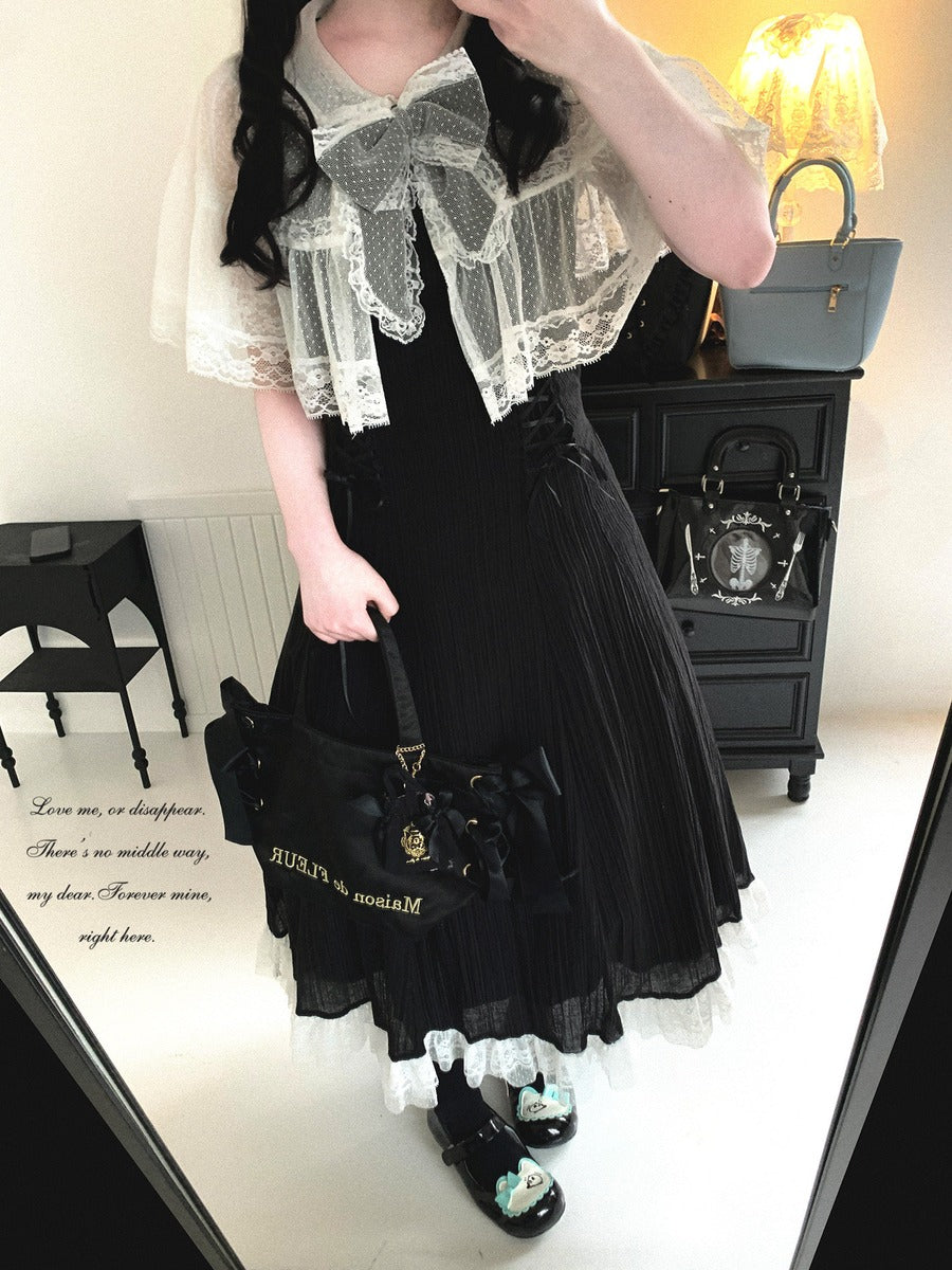 Person wearing a black outfit with white lace details, holding a black handbag.