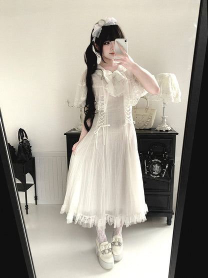 Person wearing a white lace dress in a room with a mirror.