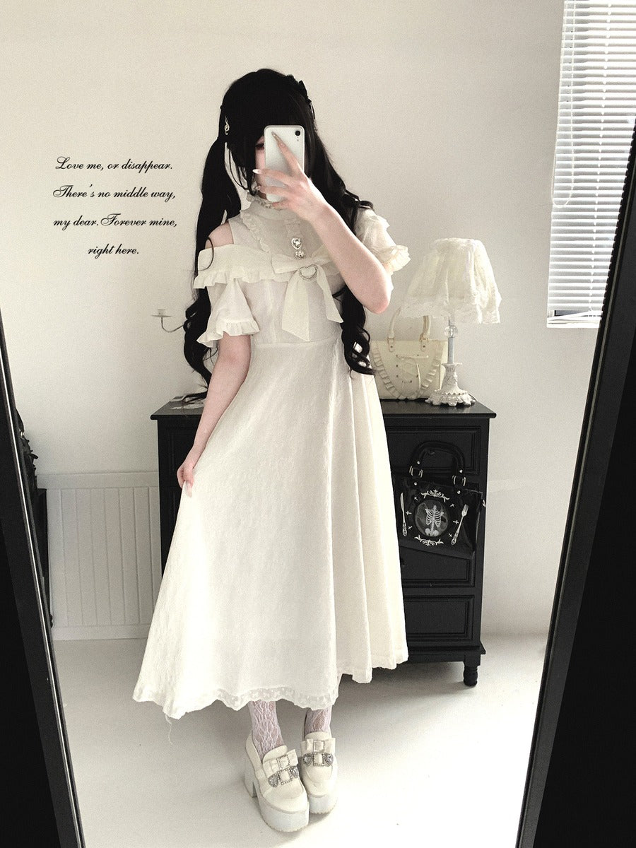 Person wearing a white dress with ruffled sleeves in a room.