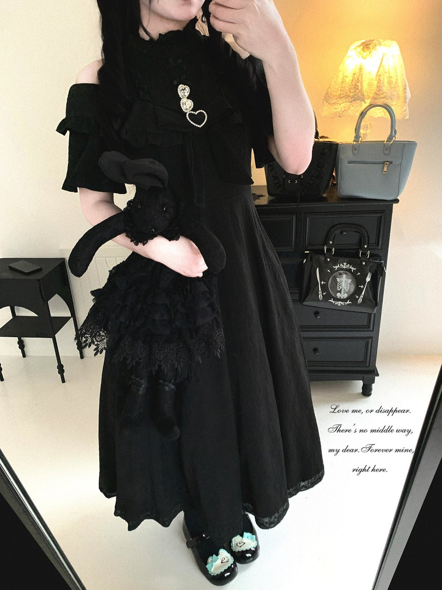 Person wearing a black outfit with ruffled details in a room setting.