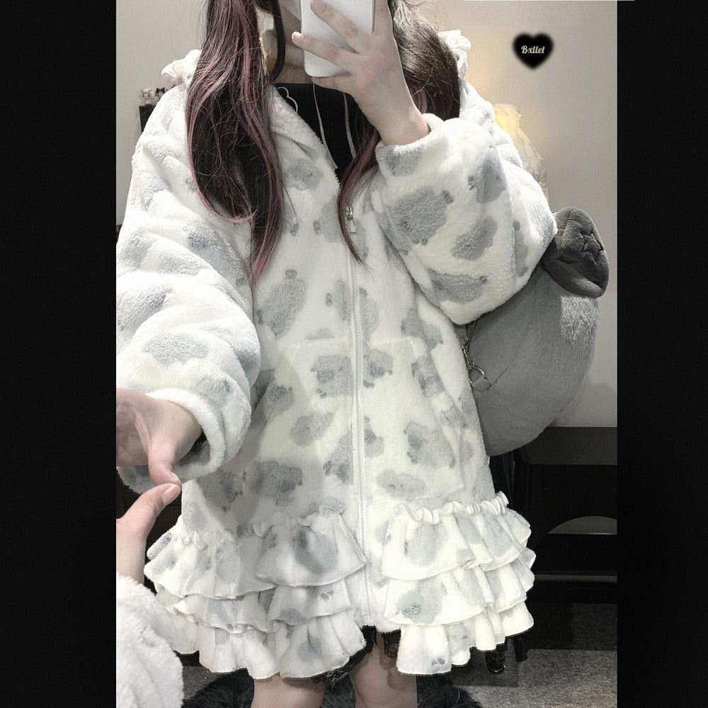 Person wearing a white and gray patterned outfit with ruffled layers.
