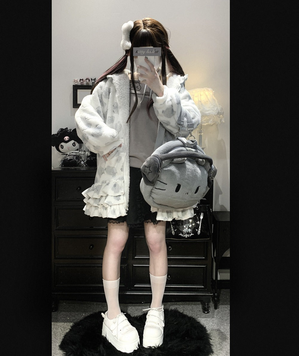 Person wearing a white outfit with a fluffy texture, holding a large gray plush toy, in a room setting.