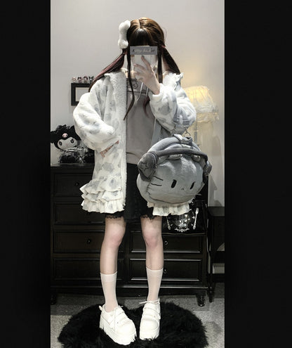 Person wearing a white outfit with a fluffy texture, holding a large gray plush toy, in a room setting.
