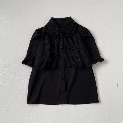 Black ruffled blouse and skirt set on a white background