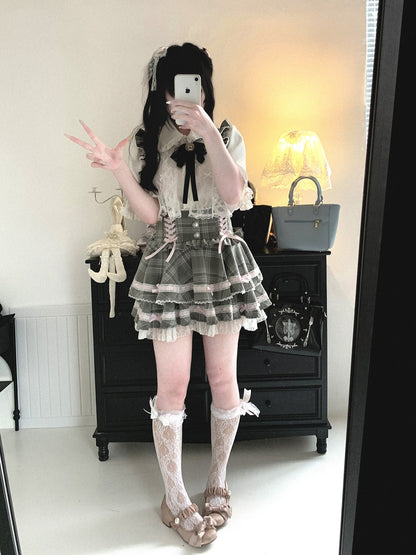 Person in a detailed outfit with a plaid skirt, lace top, and white stockings taking a mirror selfie.