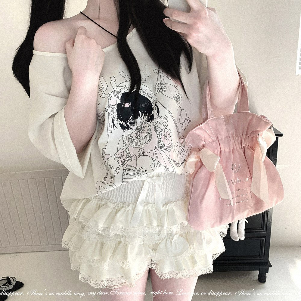 A person takes a mirror selfie wearing a cream off-the-shoulder top with a black anime-style graphic, matching cream ruffled shorts, and carrying a light pink drawstring bag with a large ribbon bow.