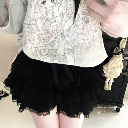 A person wearing a light gray heathered t-shirt with a black and white anime illustration, paired with a layered black ruffled tulle skirt with lace trim. A cream-colored plush bunny bag hangs from a black cabinet in the background.