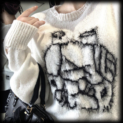 White sweater with black abstract design worn by a person