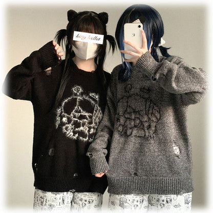 Two people wearing matching black and gray sweaters with skull designs, standing against a plain background.