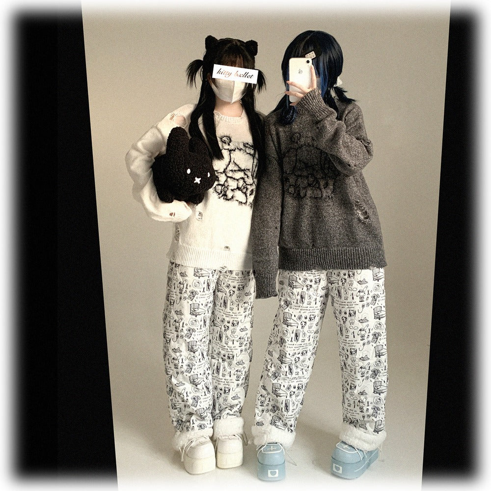 Two people wearing matching outfits with patterned pants and sweaters against a plain background.