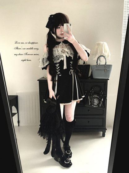 Person wearing a black and white outfit with lace details, standing in a room.