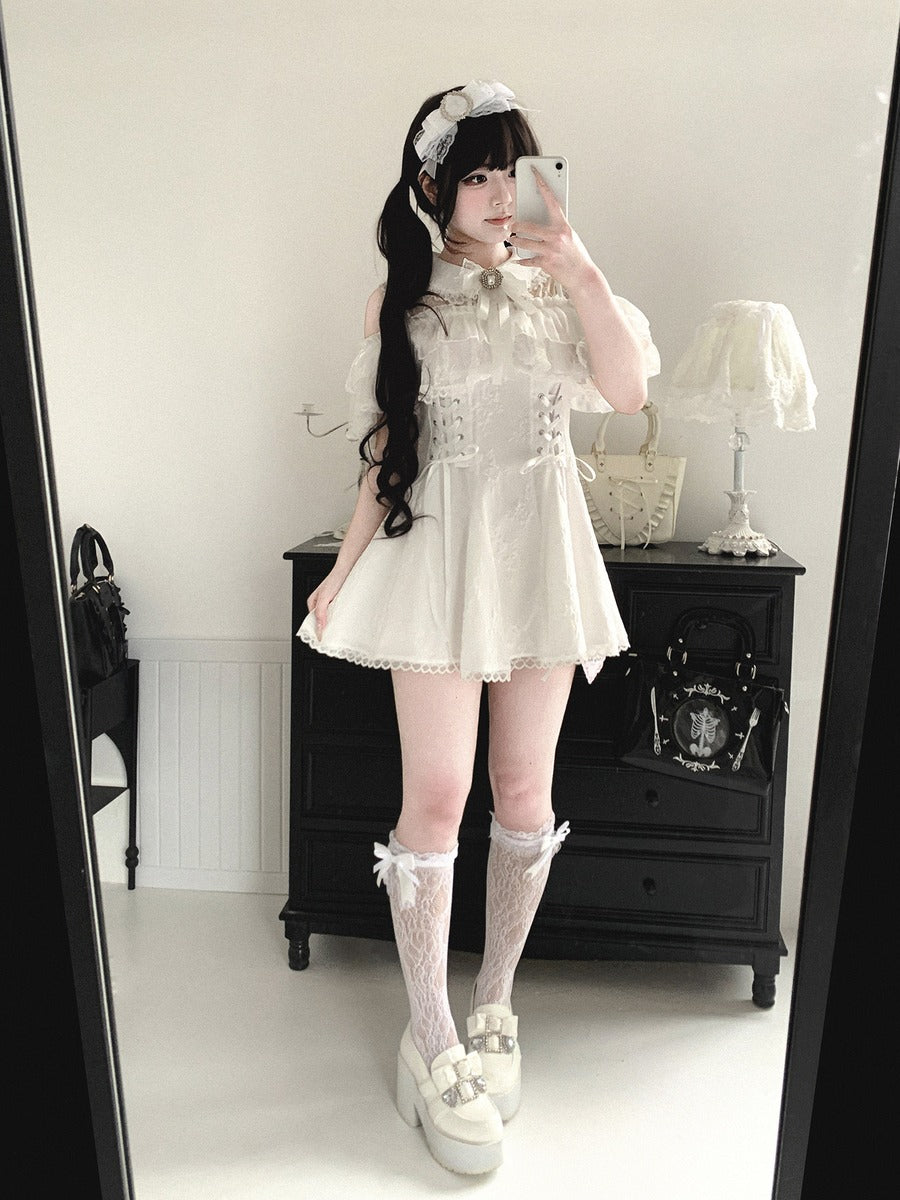 Person wearing a white dress with lace details in a room.