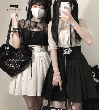 Two women in gothic Lolita fashion with black and white outfits, holding a black bag.