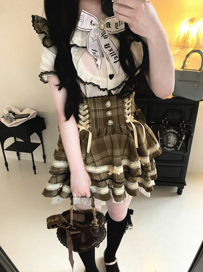 Person wearing a detailed outfit with plaid skirt and lace details in a room.