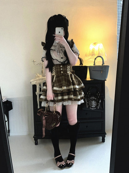 Person taking a mirror selfie wearing a plaid skirt and lace top in a room.