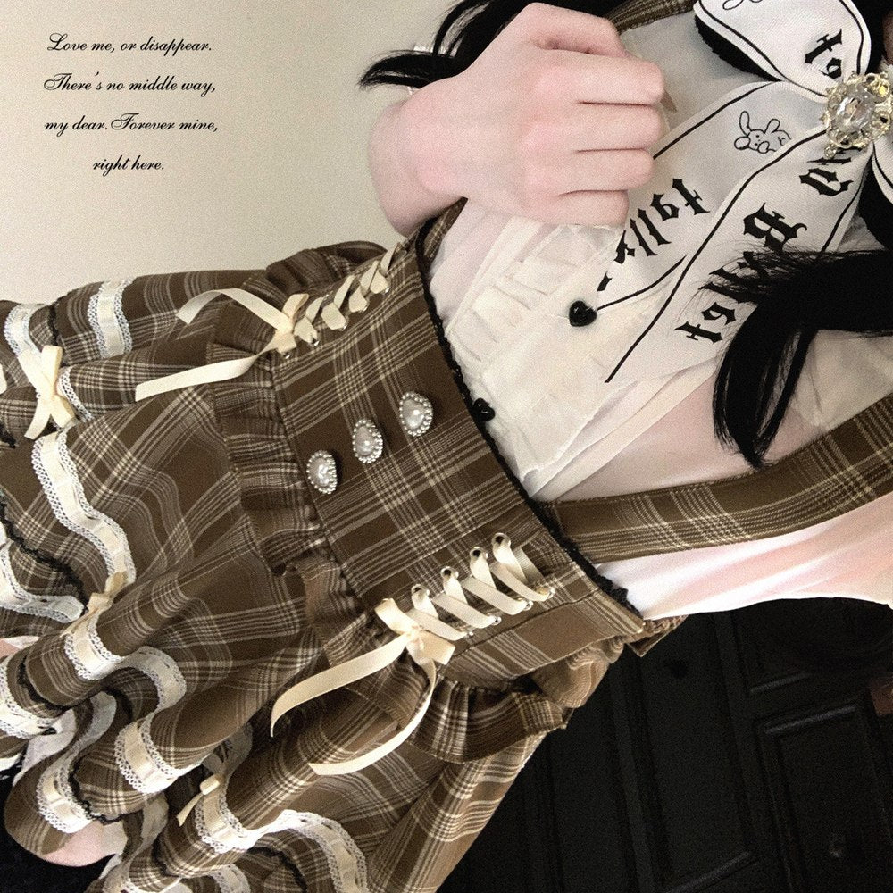 Plaid dress with ruffled details and a white blouse with black text and graphics.