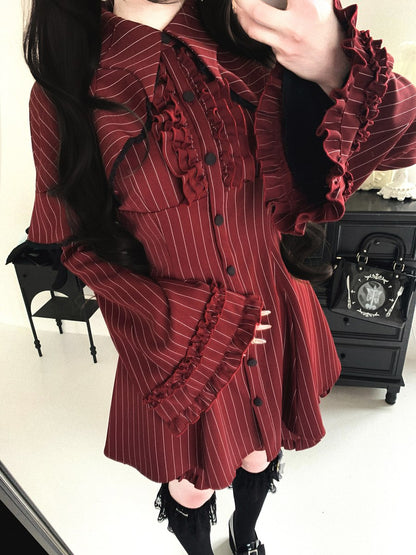Person wearing a red and black striped dress with ruffled details, standing in front of a mirror.