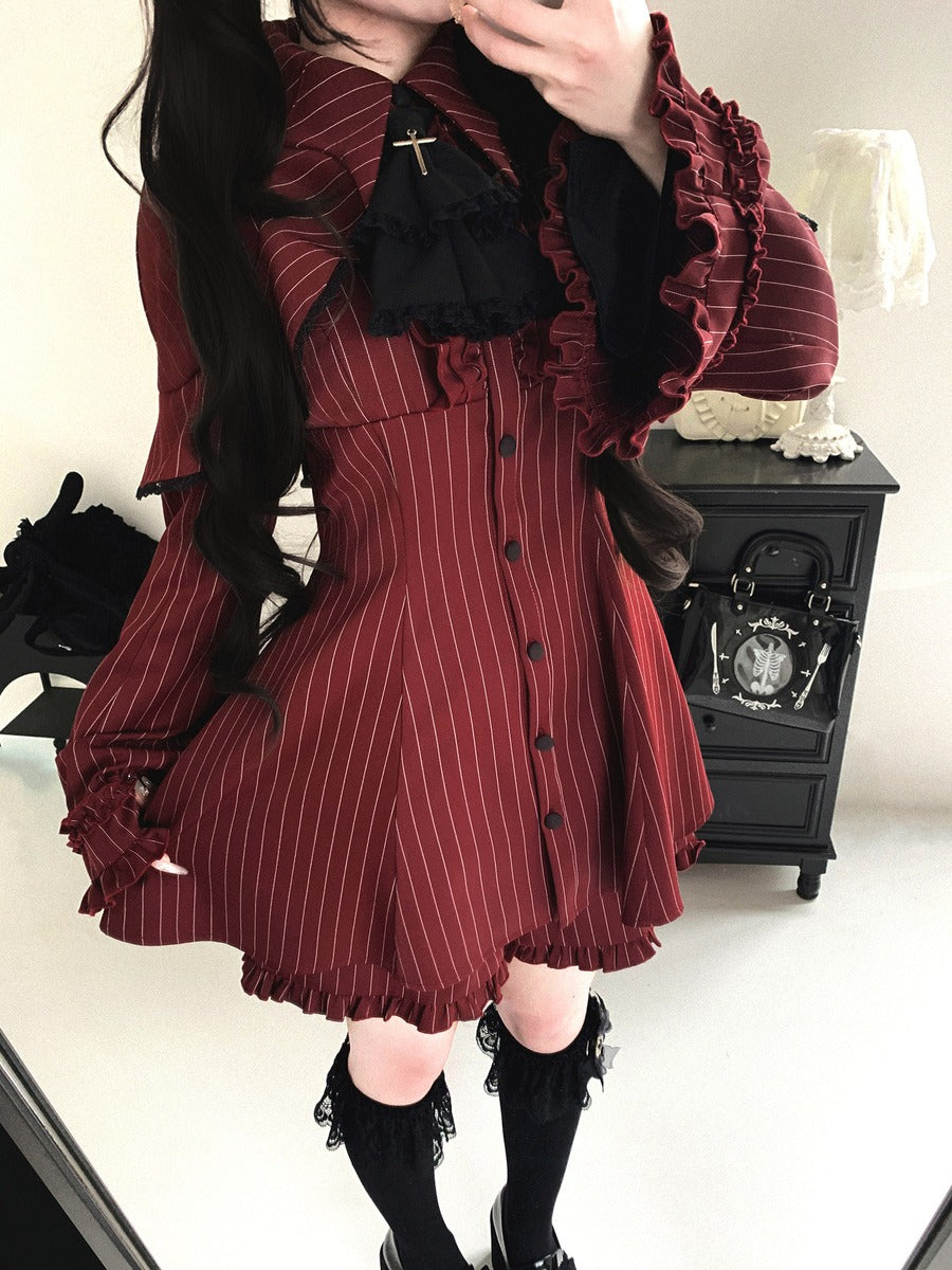 Person wearing a red pinstripe dress with black accents in an indoor setting.