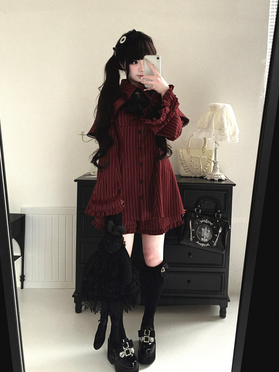 Person wearing a dark red dress with black accents in a room.
