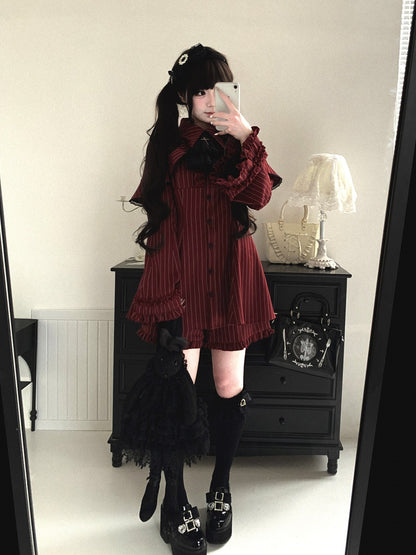 Person wearing a dark red dress with black accents in a room.