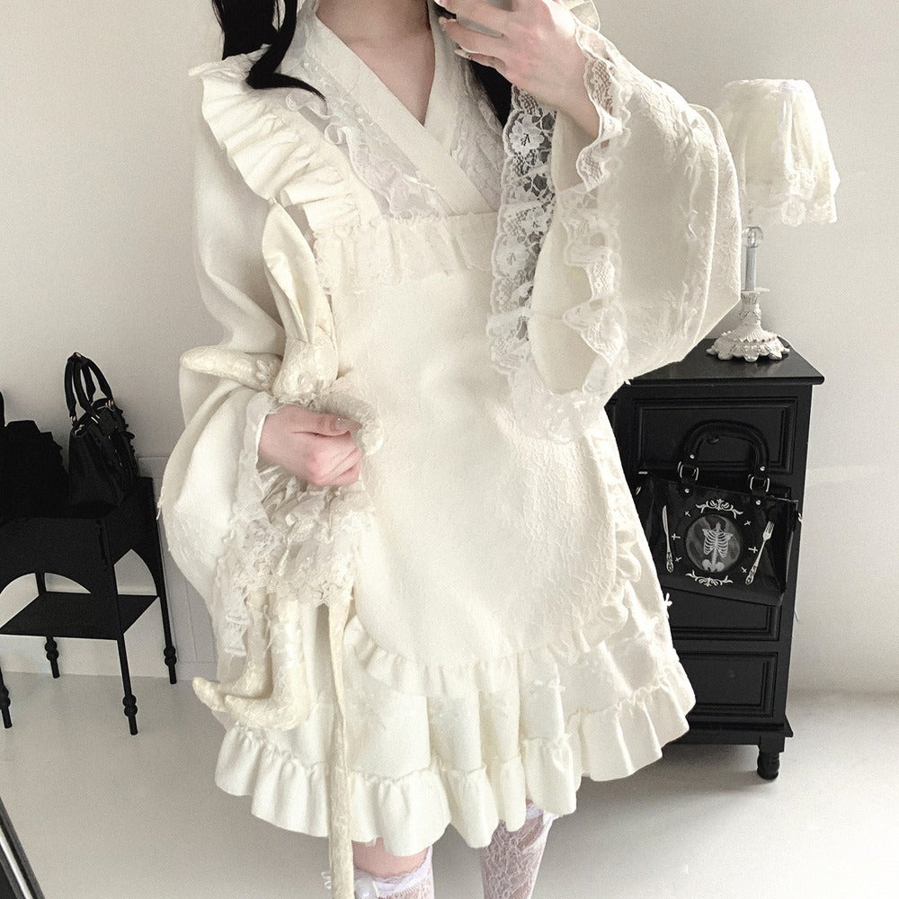 Person wearing a white kimono lace dress in a room with black furniture.