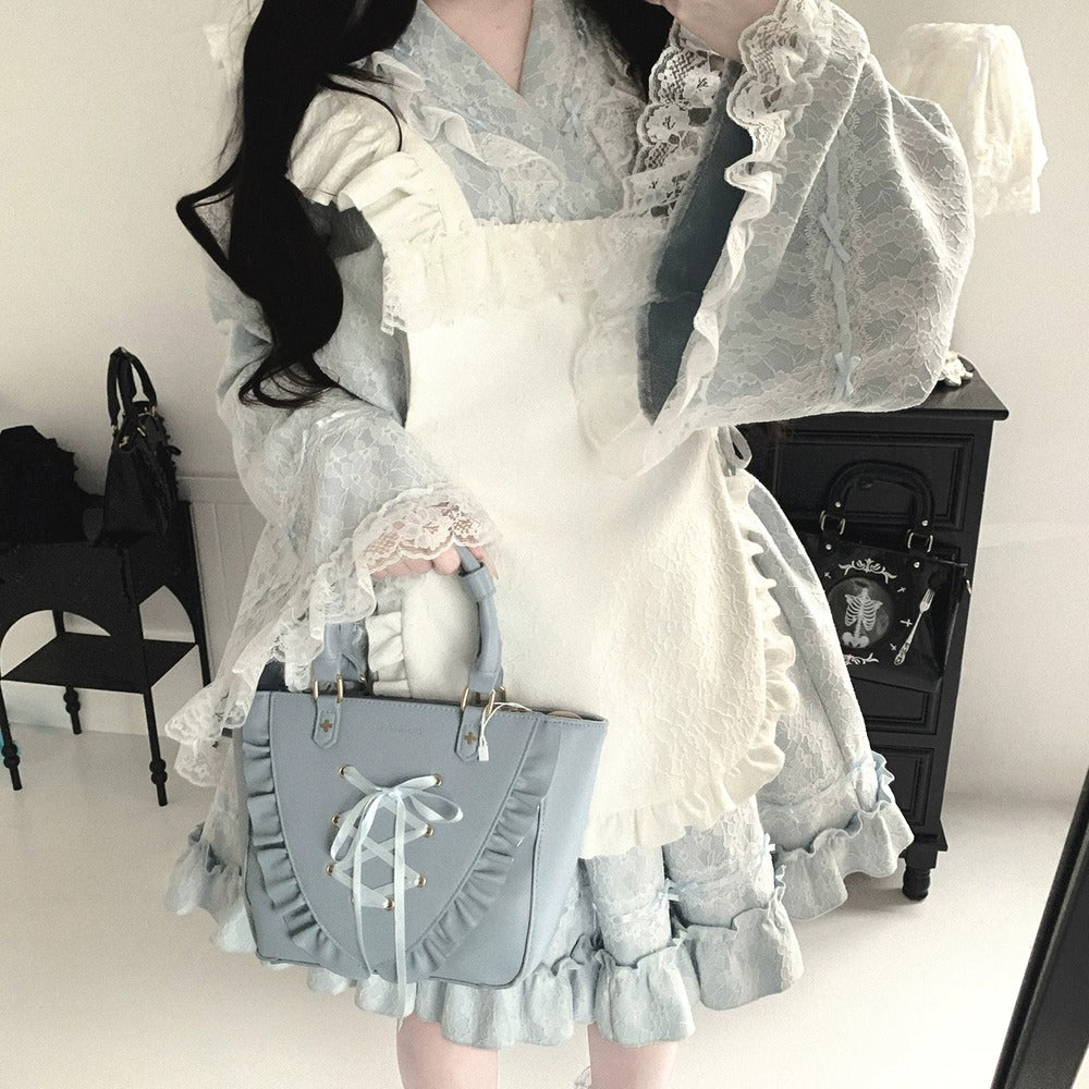 Person wearing a detailed kimono white and blue dress with a matching handbag in an indoor setting.