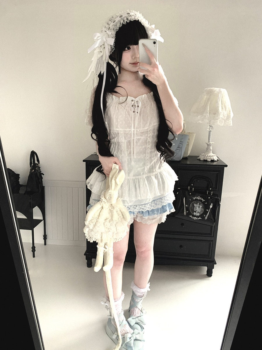 Person wearing a white lace outfit with a black background