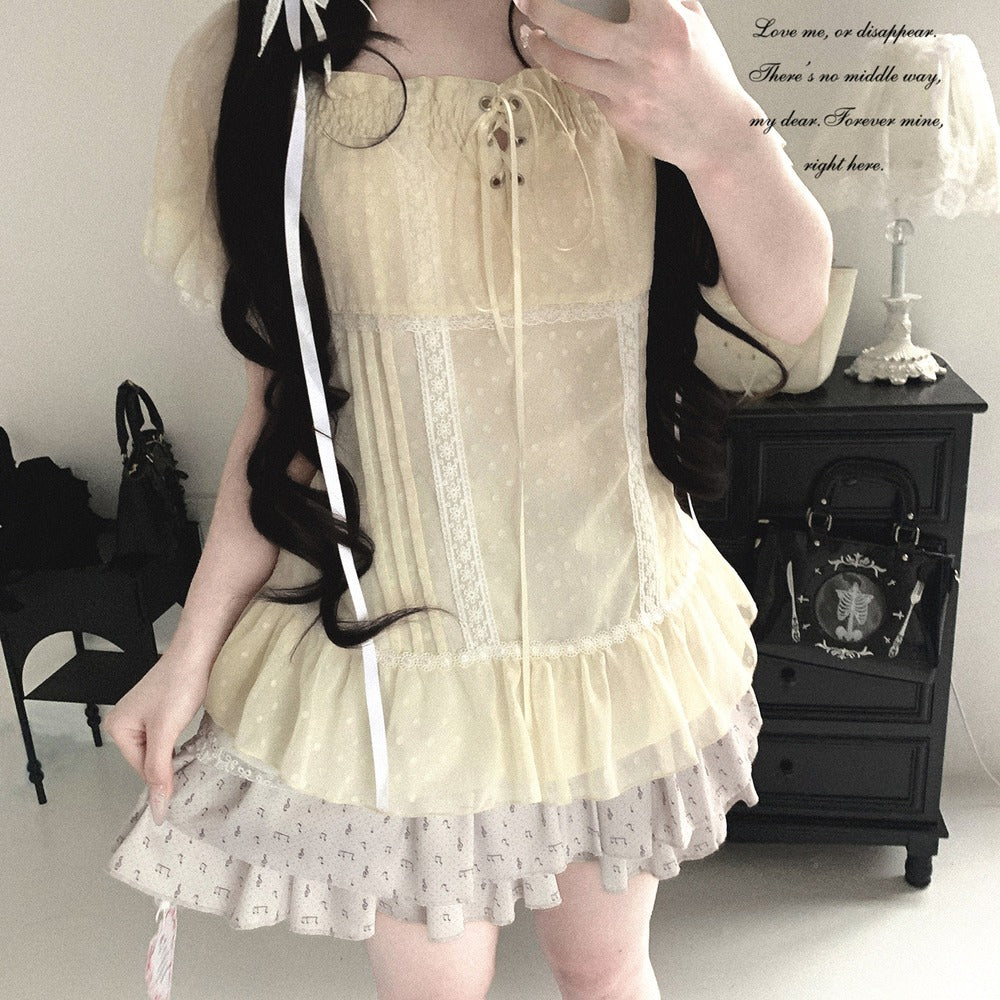 Person wearing a light-colored dress with lace details in an indoor setting.