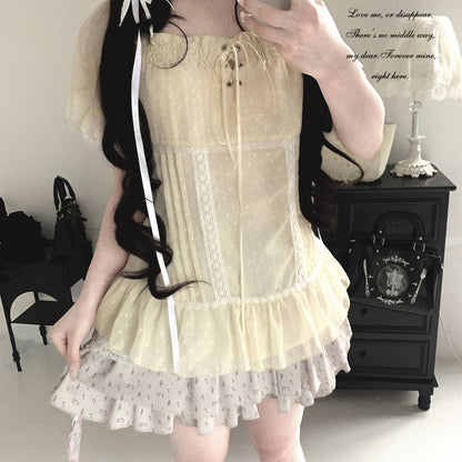 Person wearing a light-colored dress with lace details in an indoor setting.