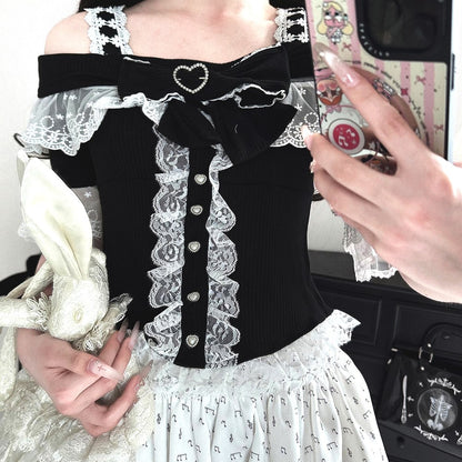 Person wearing a black and white lace outfit with a large bow, holding a phone case.