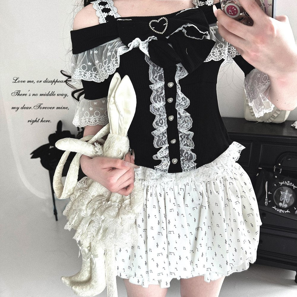 Person wearing a black and white outfit with lace details, holding a white rabbit plush toy.