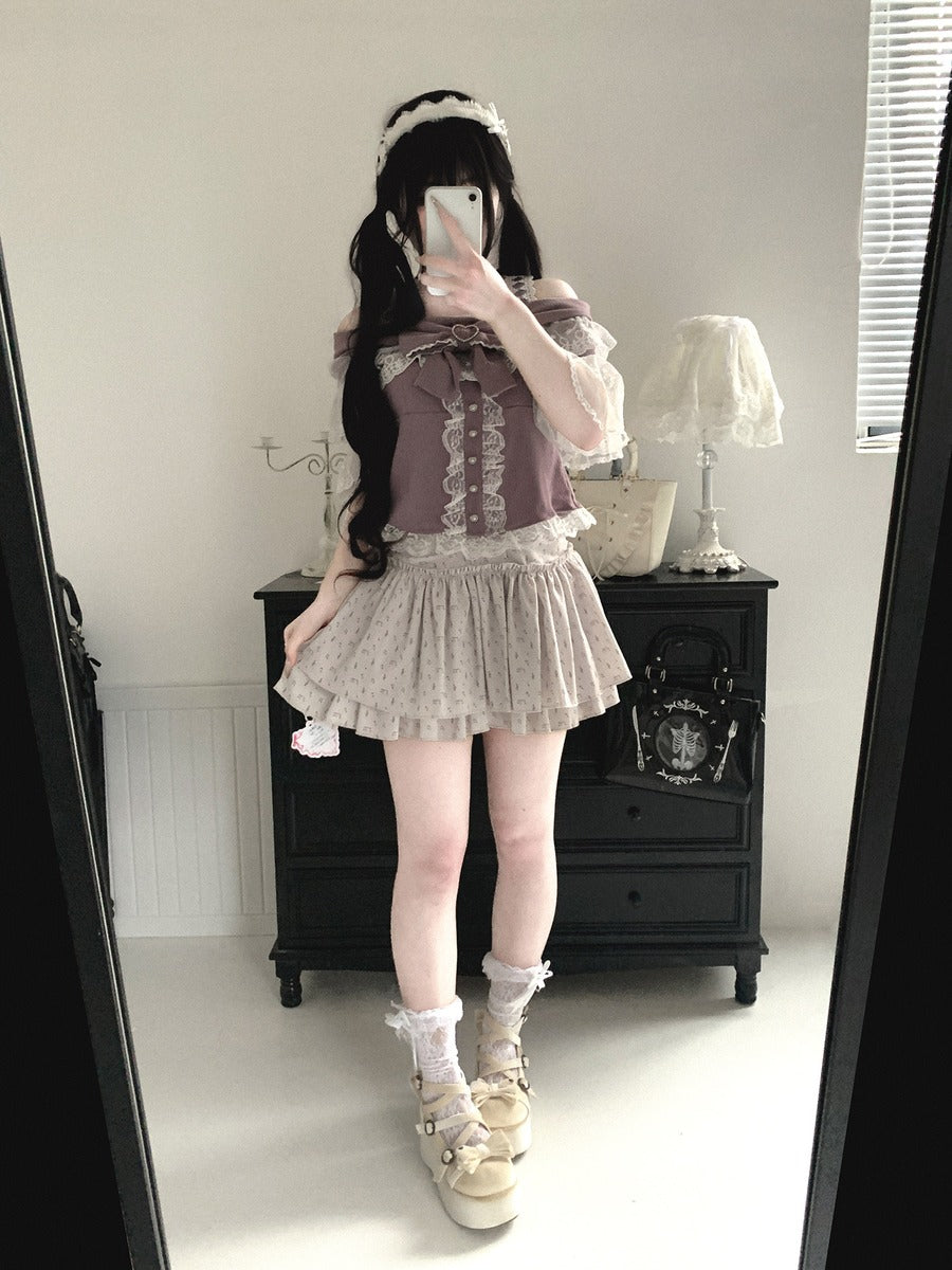 Person taking a mirror selfie wearing a layered outfit with a skirt and top.