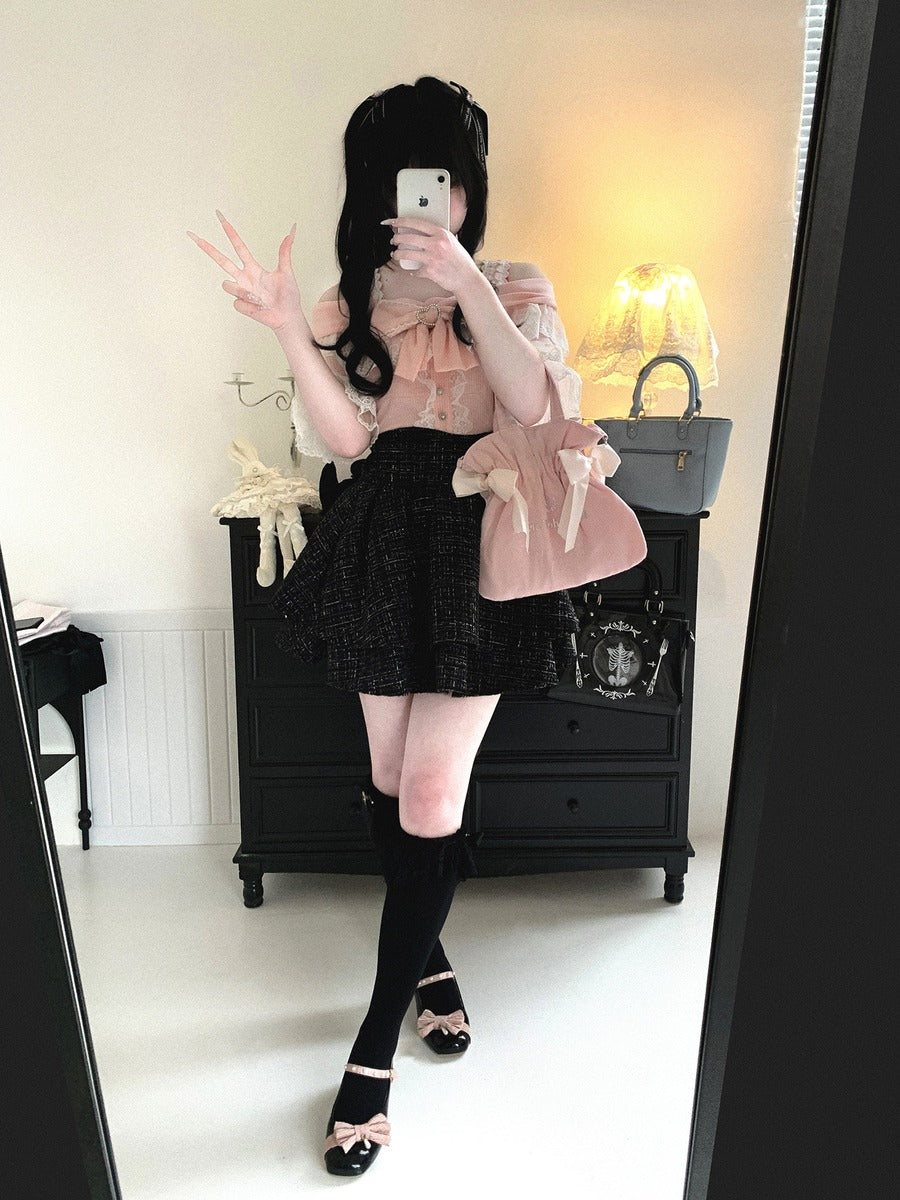 Person wearing a black and pink outfit with a skirt and top, standing in a room.