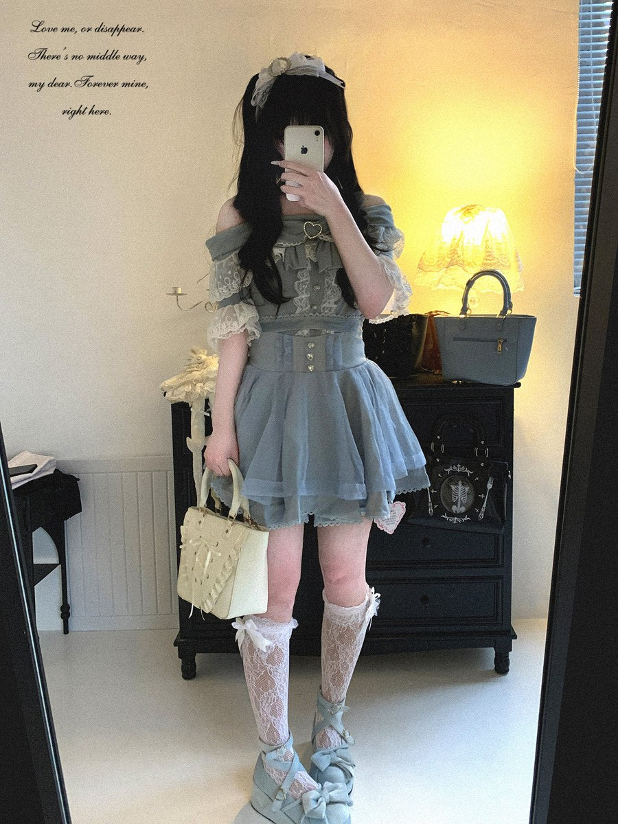Person wearing a light blue dress with lace details in a room.